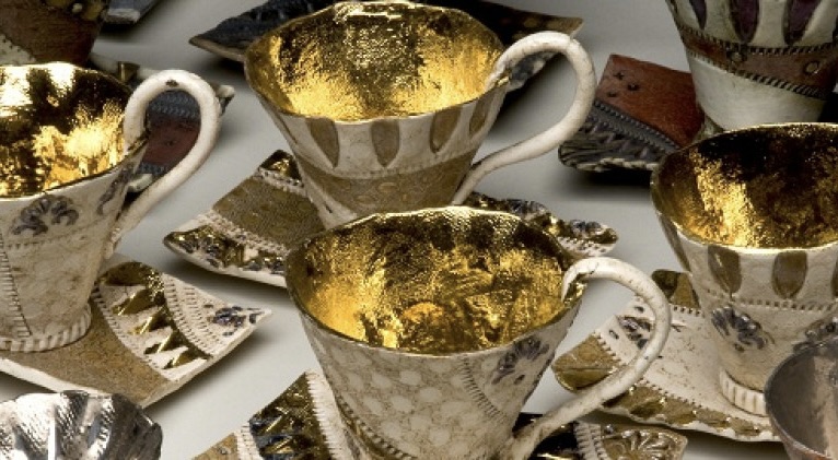 Detail showing teacups and saucers. The insides of the cups are coated in gold leaf