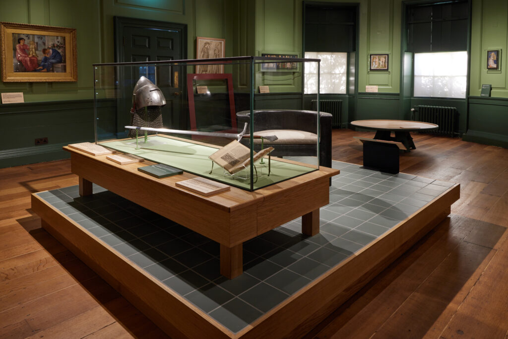 Installation image of Gallery 1 showing a display with helmet and sword